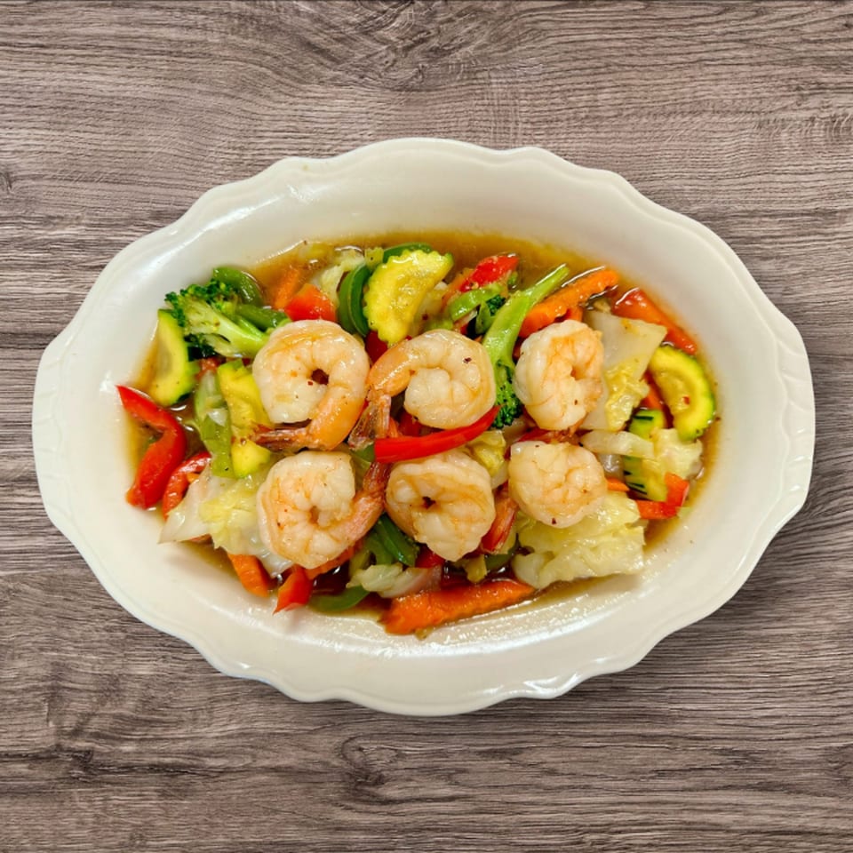 Kwan Thai Cuisine's shrimp and mixed vegetables, including broccoli, zucchini, and carrots, in a savory sauce.